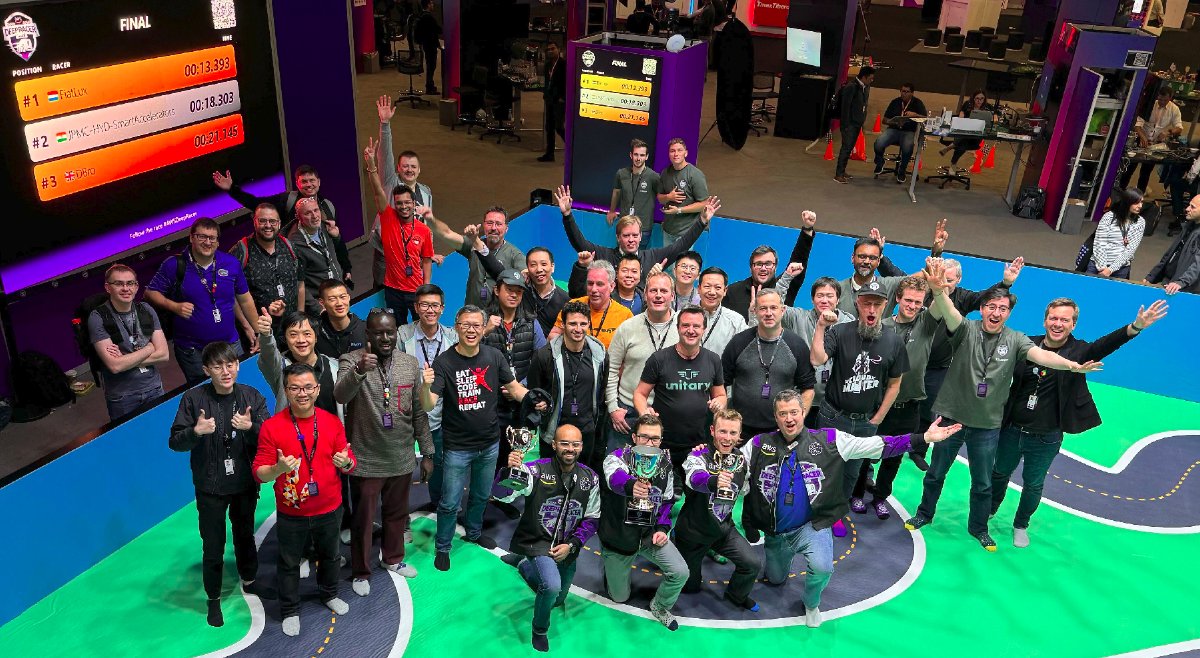 AWS DeepRacer Community, AWS re:Invent 2023 | cite:deepracing1 A picture of many AWS DeepRacer Community members on a racing track in 2023